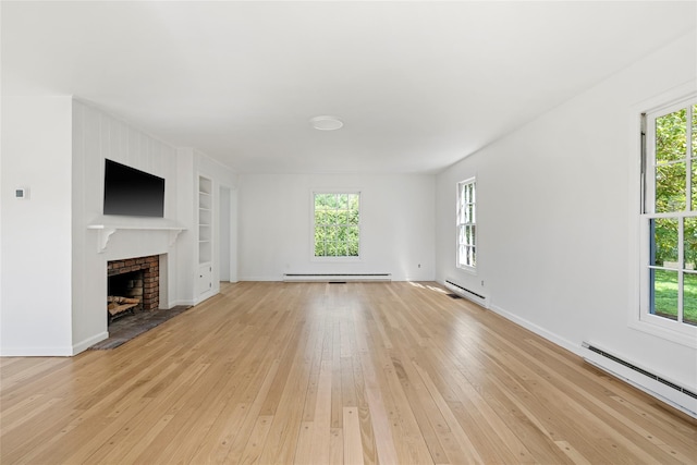 96 Audubon Ave, Bridgehampton, NY 11932 - unfurnished living room with built in shelves, a baseboard radiator, and a healthy amount of sunlight