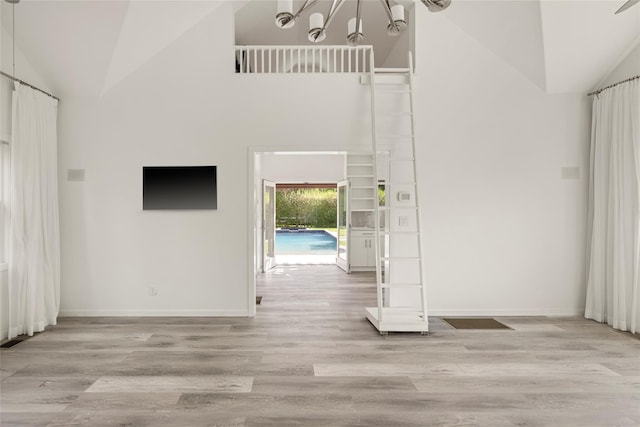 96 Audubon Ave, Bridgehampton, NY 11932 - interior space with an inviting chandelier, wood finished floors, baseboards, and high vaulted ceiling