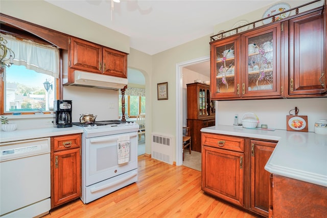 249Slosson Ave, Staten Island, NY 10314 - kitchen featuring under cabinet range hood, white appliances, arched walkways, light countertops, and light wood-type flooring