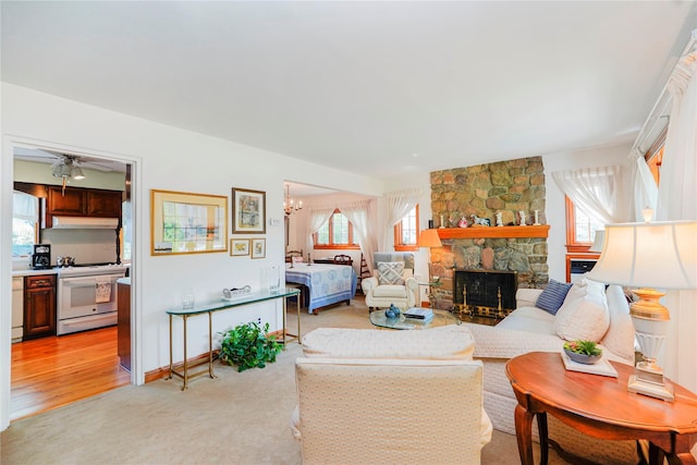 249Slosson Ave, Staten Island, NY 10314 - living area with light carpet, ceiling fan with notable chandelier, a stone fireplace, and a healthy amount of sunlight