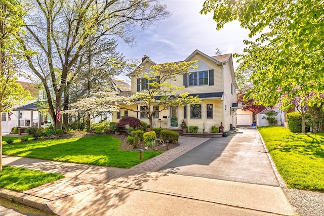 view of front of property featuring an outdoor structure, a front lawn, and driveway