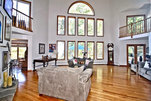 36 Ridgetop Dr, Tomkins Cove, NY 10986 - living room with a high ceiling, wood finished floors, a baseboard heating unit, french doors, and baseboards