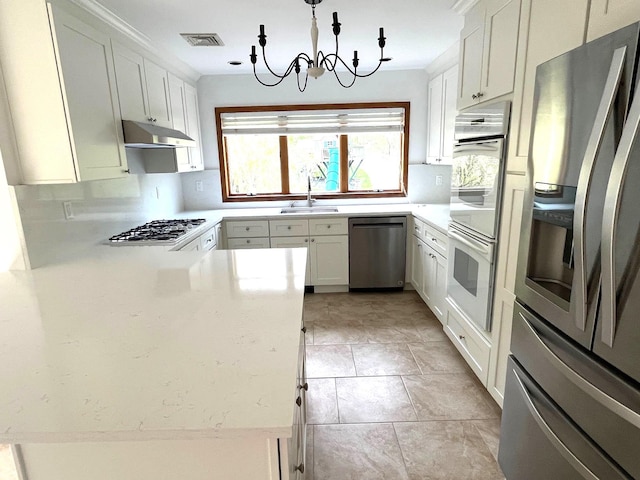 36 Ridgetop Dr, Tomkins Cove, NY 10986 - kitchen with appliances with stainless steel finishes, under cabinet range hood, a sink, a chandelier, and white cabinets