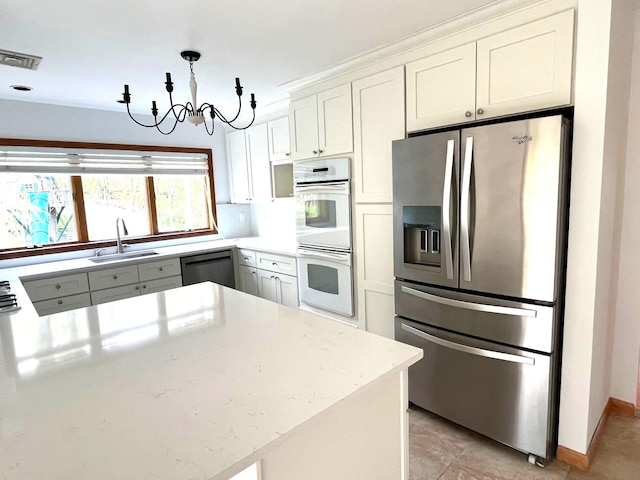 36 Ridgetop Dr, Tomkins Cove, NY 10986 - kitchen with stainless steel appliances, a sink, a chandelier, white cabinets, and a peninsula