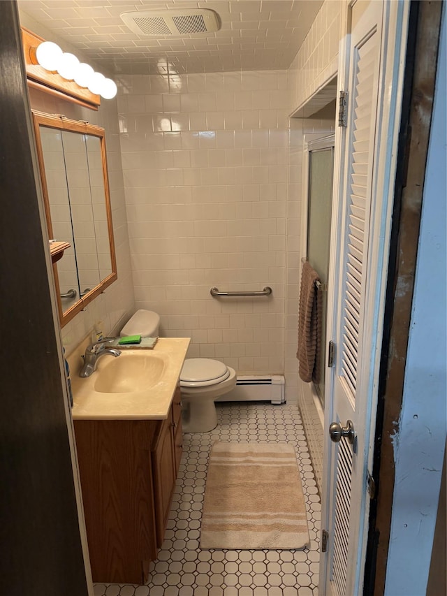 56 Martin Dr, Wappingers Falls, NY 12590 - full bath featuring a baseboard radiator, a shower with shower door, vanity, tile walls, and toilet