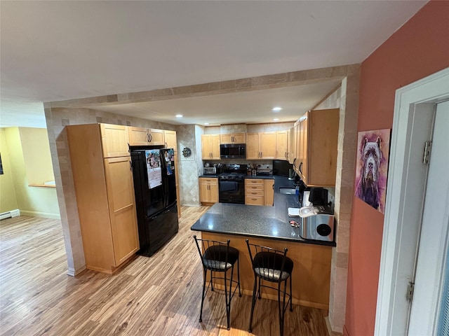 56 Martin Dr, Wappingers Falls, NY 12590 - kitchen featuring black appliances, dark countertops, a peninsula, light wood finished floors, and light brown cabinets