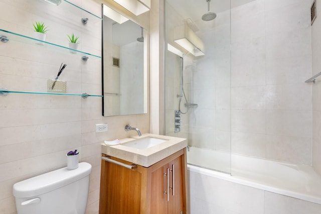 full bathroom featuring a combined bath / shower with rainfall shower, toilet, tile walls, and vanity