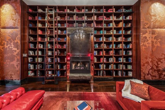 living area with wall of books and wallpapered walls
