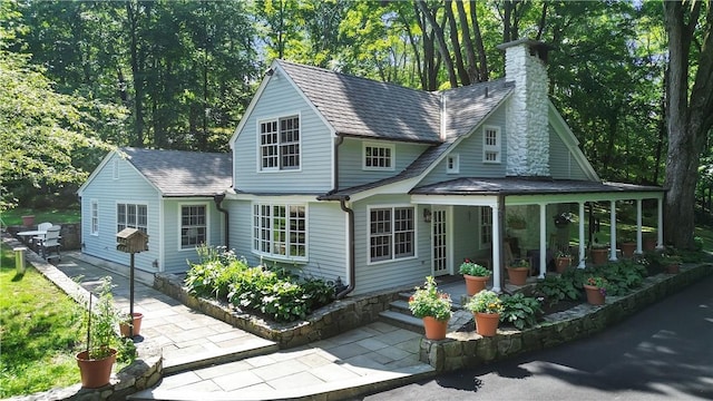 back of property featuring a patio and a chimney