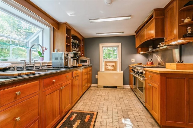 kitchen with brown cabinets, open shelves, a sink, baseboards, and double oven range