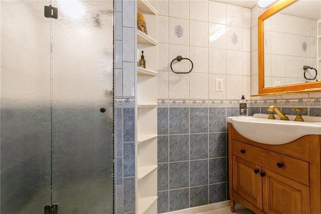 full bath featuring vanity, a stall shower, and tile walls