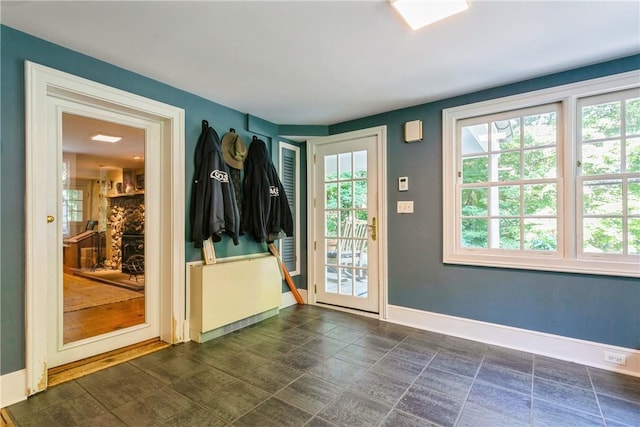 doorway to outside featuring baseboards and a healthy amount of sunlight