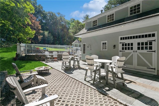 view of patio with fence, outdoor dining space, and a fire pit