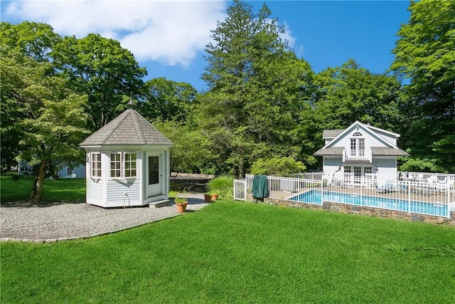view of yard with a fenced in pool, fence, and an outdoor structure