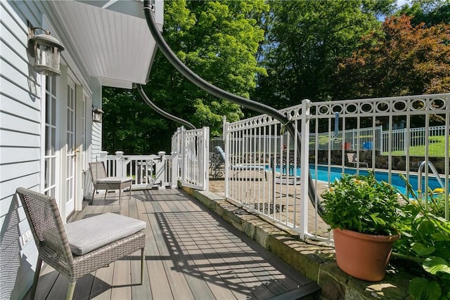 deck with fence and an outdoor pool