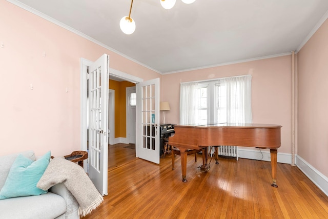 sitting room with baseboards, ornamental molding, french doors, and hardwood / wood-style floors