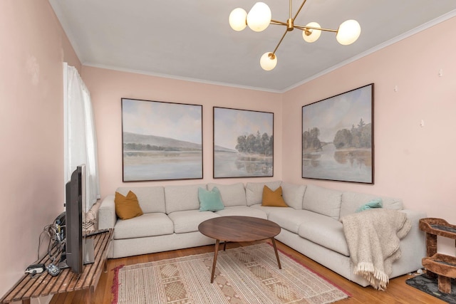living room with ornamental molding, wood finished floors, and a notable chandelier