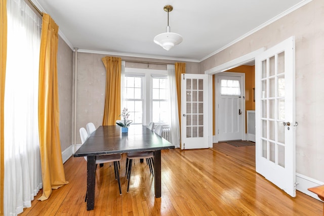 dining space featuring ornamental molding, french doors, and light wood-type flooring