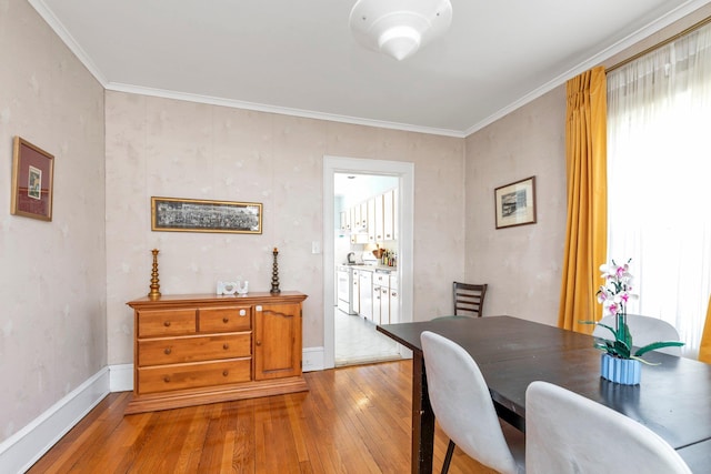dining room featuring crown molding, baseboards, and hardwood / wood-style floors