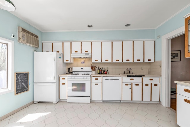 kitchen featuring a sink, light countertops, white cabinets, under cabinet range hood, and white appliances