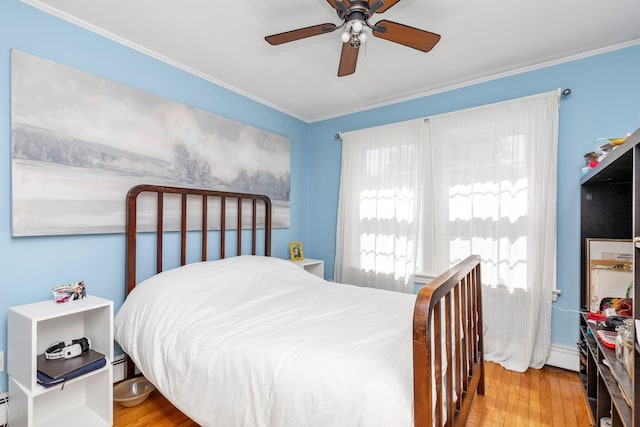 bedroom featuring crown molding, a ceiling fan, and wood finished floors
