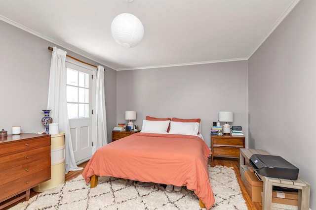 bedroom with crown molding and wood finished floors