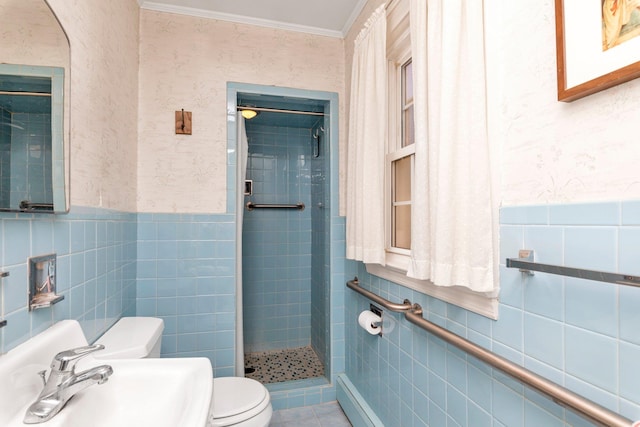 bathroom featuring a sink, tile walls, a shower stall, and toilet
