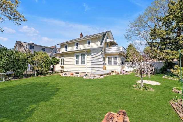 rear view of house with a yard, fence, and a chimney