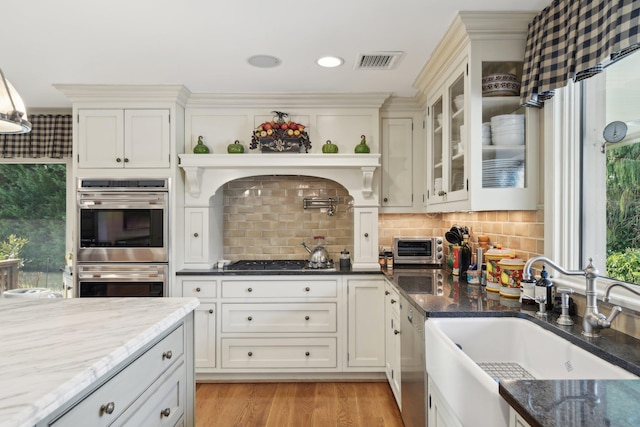 1325 Huckleberry Ln, Hewlett Harbor, NY 11557 - kitchen with appliances with stainless steel finishes, a sink, dark stone counters, light wood-type flooring, and tasteful backsplash