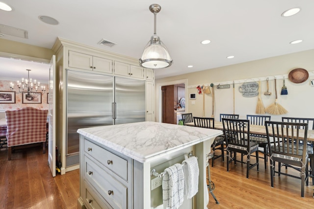 1325 Huckleberry Ln, Hewlett Harbor, NY 11557 - kitchen featuring stainless steel built in fridge, light stone countertops, pendant lighting, a center island, and wood finished floors