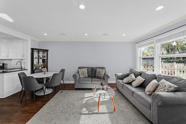 living area featuring ornamental molding, recessed lighting, and dark wood-type flooring