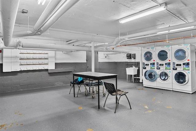 common laundry area with a sink, stacked washer / dryer, and washer and clothes dryer