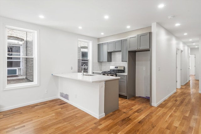1236 Evergreen Ave, Bronx, NY 10472 - kitchen with gray cabinetry, stainless steel gas range, a sink, light countertops, and light wood-style floors