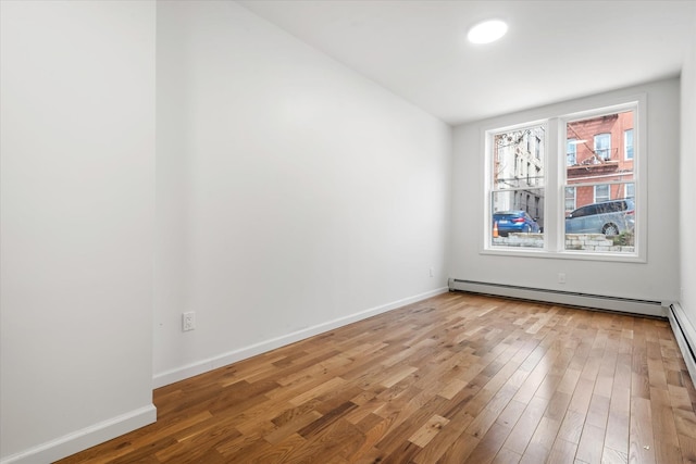 1236 Evergreen Ave, Bronx, NY 10472 - spare room featuring a baseboard heating unit, light wood-type flooring, and baseboards