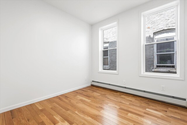 1236 Evergreen Ave, Bronx, NY 10472 - unfurnished room with light wood-style floors, a baseboard radiator, baseboards, and vaulted ceiling