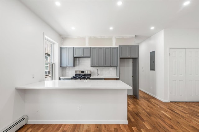 1236 Evergreen Ave, Bronx, NY 10472 - kitchen featuring baseboard heating, stainless steel gas range oven, electric panel, gray cabinetry, and tasteful backsplash