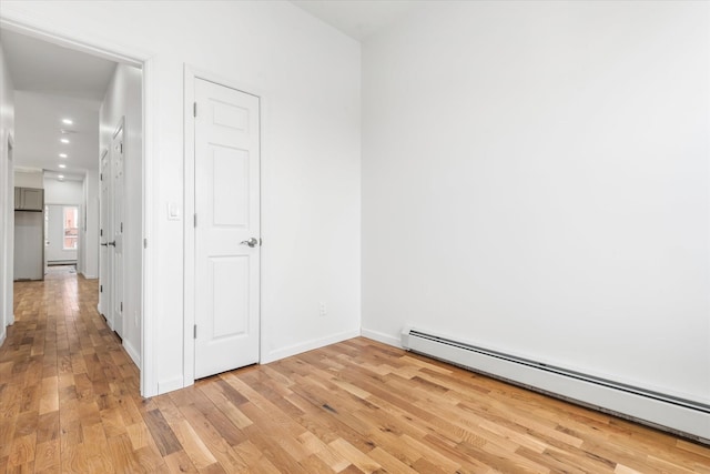1236 Evergreen Ave, Bronx, NY 10472 - empty room featuring a baseboard radiator, light wood-style flooring, baseboards, and recessed lighting