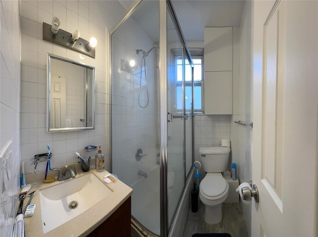 full bath featuring vanity, toilet, tile walls, tasteful backsplash, and an enclosed shower