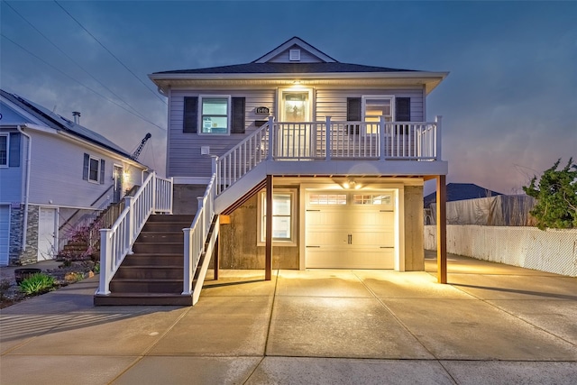 view of front of home featuring concrete driveway, fence, stairway, and a garage