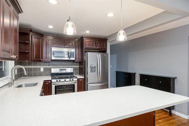 kitchen with backsplash, open shelves, a sink, light countertops, and stainless steel appliances