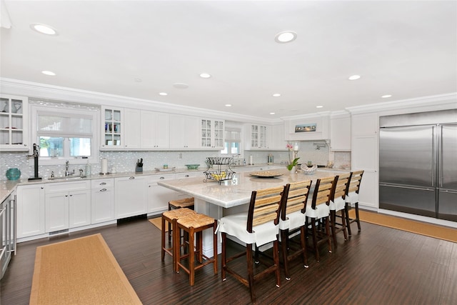879 Oceanfront, Long Beach, NY 11561 - kitchen featuring a sink, white cabinetry, a kitchen breakfast bar, ornamental molding, and backsplash
