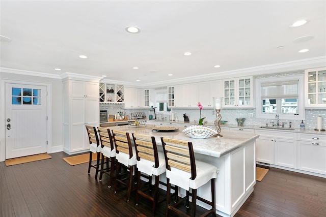 879 Oceanfront, Long Beach, NY 11561 - kitchen featuring a sink, a center island, decorative backsplash, white cabinetry, and ornamental molding