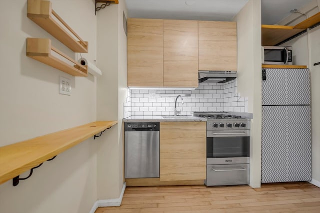 kitchen featuring a sink, under cabinet range hood, light wood-style floors, open shelves, and appliances with stainless steel finishes