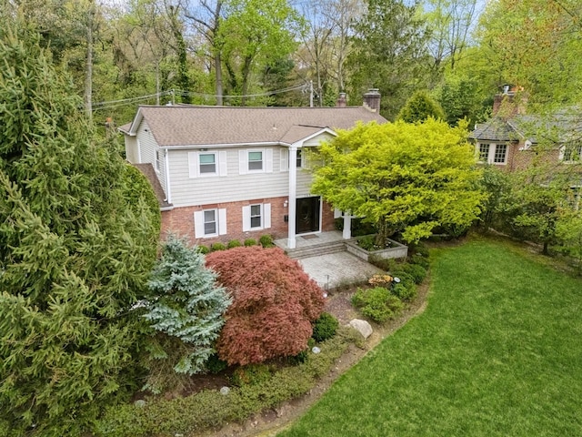 165 Tara Dr, Roslyn, NY 11576 - view of front facade with brick siding, a front yard, and a chimney