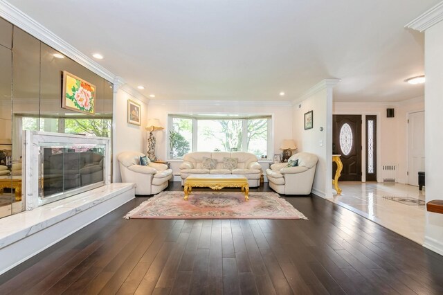 165 Tara Dr, Roslyn, NY 11576 - living room featuring wood finished floors, crown molding, radiator, recessed lighting, and baseboards