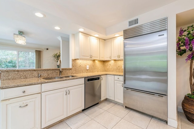 165 Tara Dr, Roslyn, NY 11576 - kitchen with appliances with stainless steel finishes, a sink, tasteful backsplash, light stone counters, and light tile patterned flooring