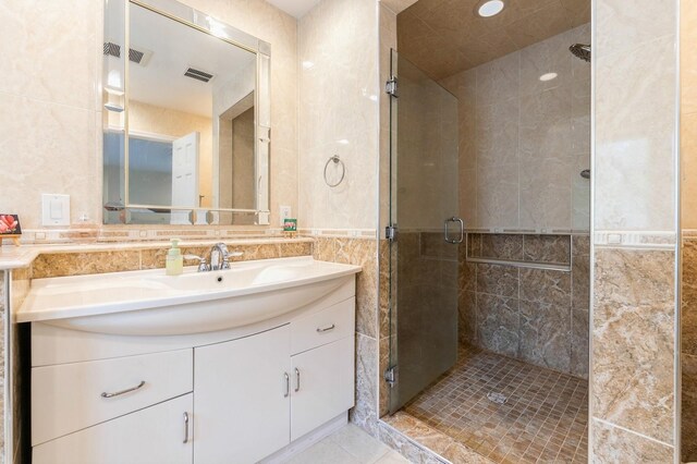 165 Tara Dr, Roslyn, NY 11576 - full bath featuring tile walls, a stall shower, vanity, and tile patterned floors