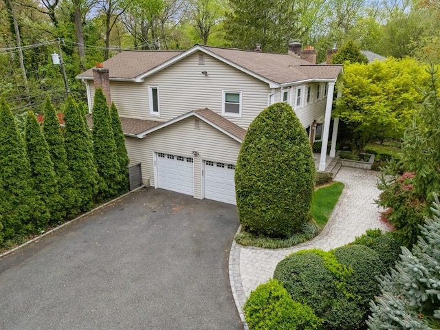 165 Tara Dr, Roslyn, NY 11576 - view of front of home featuring asphalt driveway, roof with shingles, a chimney, and a garage