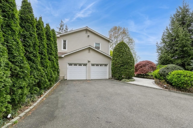 165 Tara Dr, Roslyn, NY 11576 - view of side of property with asphalt driveway and an attached garage