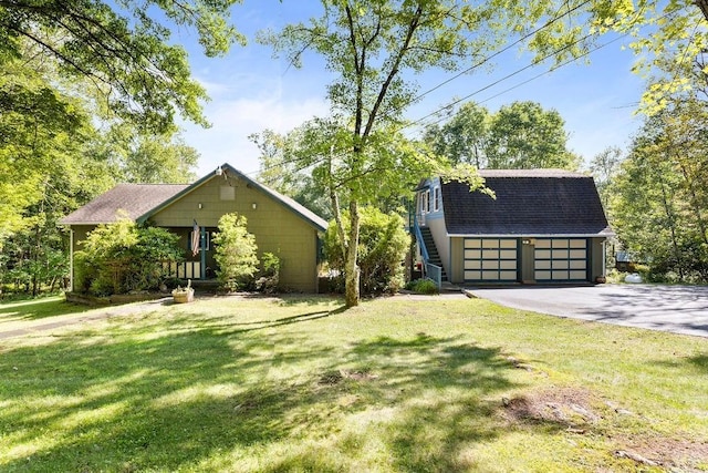 51 Strong Rd, Ferndale, NY 12734 - view of front facade featuring a shingled roof, a front lawn, aphalt driveway, a garage, and an outbuilding
